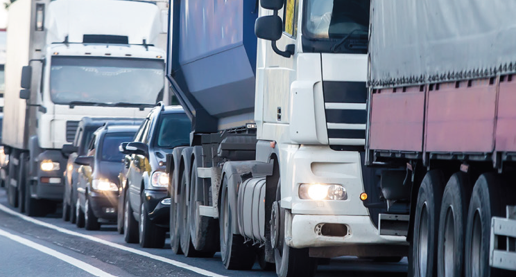 Een drukke weg met vrachtwagens en personenauto's